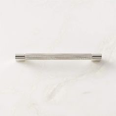 a white marble counter top with a metal object on it's side and a silver handle