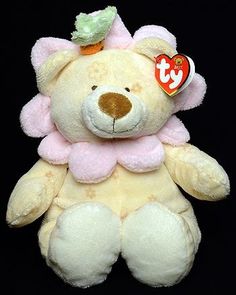 a white teddy bear with a green bow on it's head and a tag in its ear