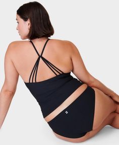 Our ultra-flattering tankini top for all-day comfort at the beach or pool. Part-recycled Xtra Life Lycra is 5 times more durable than elastane. Smoothing, longline fit for extra coverage with a scoop neck and strappy back. Resistant to damage from chlorine and UV50+ rays. Features in-bult bra shelf and removable padding. Front length: 44.5cm / 18”. Model wears size L and is 178cm/5'10" tall. Style Code: SB9254Colour: Black Seamless Summer Beach Activewear, Athleisure Cross Back Swimwear For Summer, Athleisure Cross-back Swimwear For Summer, Seamless Summer Activewear For The Beach, Sporty Elastane Tankini For Beach, Stretch Cross Back Swimwear For Workout, Seamless Beachwear Activewear For Poolside, Stretch Cross-back Swimwear For Workout, Beach Stretch Activewear, Bra Friendly