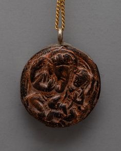 an ancient coin is hanging on a chain