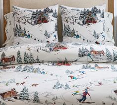 a bed with ski themed sheets and pillows