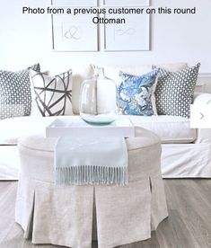 a living room with white furniture and pillows