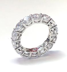 Our eternity band is a showstopper. Featuring round brilliant cut prong set cubic zirconia stones. Wear the band solo or stack with other rings, either way the look is luxurious. See our other bands for stacking. half sizes available. The ring on the right is also available. Item Details: TCW: 4.8 Style: Eternity Band Alternate Style: Cocktail Gender: Women's Stone Color: Clear Stone Cut: Round Stone Size: 4.5 mm Stone Material: Cubic Zirconia Stone Setting: Prong Ring Dimensions: 22 mm x 4.5 mm Moissanite Eternity Band With Vs Clarity For Anniversary, Promise Ring Eternity Band With Prong Set Moissanite, Vvs Clarity Moissanite Eternity Band For Promise, Moissanite Eternity Band With Prong Setting For Promise Ring, White Eternity Band With Vs Clarity, White Vs Clarity Round Eternity Band, Anniversary Eternity Band With Prong Setting In Cubic Zirconia, Cubic Zirconia Eternity Band With Prong Setting For Anniversary, Cubic Zirconia Eternity Ring For Anniversary