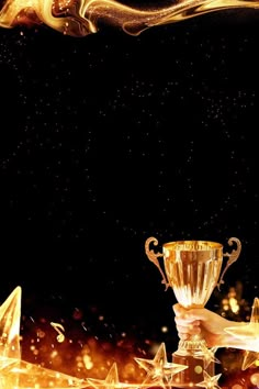 a person holding up a golden trophy over a black background with gold stars and streamers