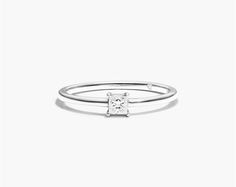 a white gold ring with a princess cut diamond