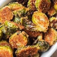 cooked brussel sprouts in a white dish with seasoning on top