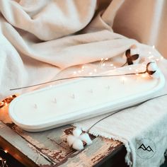 a close up of a white object with lights on it and a blanket in the background