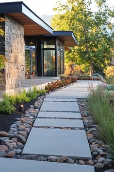 a stone walkway leading to a modern home