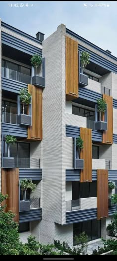 an apartment building with wooden balconies and plants on the balconies are shown