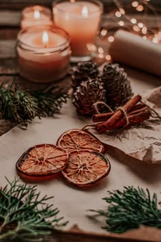 an assortment of dried orange slices on a table with pine cones, cinnamon sticks and candles