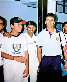 two men standing next to each other in front of a group of people wearing white shirts