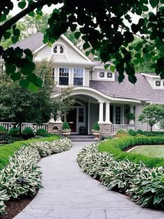 a large house surrounded by lush green trees and shrubbery in front of the entrance