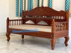 a wooden daybed sitting on top of a white floor next to a blue curtain