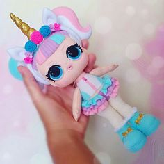 a hand holding a little doll with a unicorn outfit