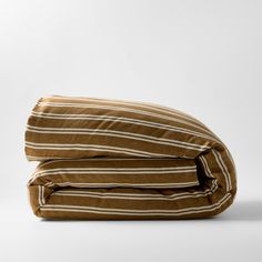 two brown and white striped pillows sitting on top of each other