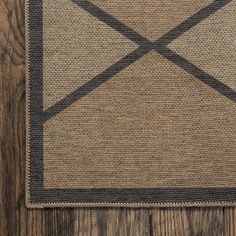 a brown and black rug on top of a wooden floor