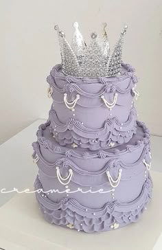 a three tiered purple cake with a crown on top