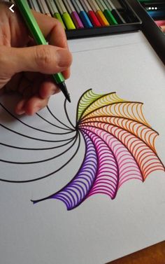 someone is drawing with colored pencils on paper