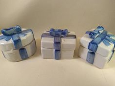 three small gift boxes with blue bows on them