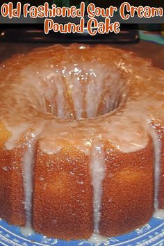 an old fashioned sour cream pound cake with icing on a blue and white plate