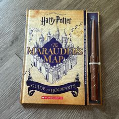 a harry potter book sitting on top of a wooden table next to a pen and eraser