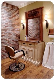 an old fashioned barber chair sits in front of a brick wall with a mirror above it