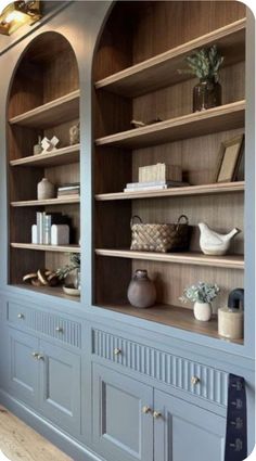 an empty bookcase with many books and vases on it