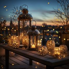 lighted lanterns are sitting on a table with lights in the night sky behind them,