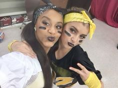 two girls with their faces painted in black and yellow