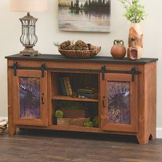 a wooden cabinet with two glass doors and a bowl on top of it, next to a lamp