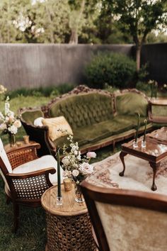 an outdoor seating area with couches, chairs and flowers in vases on tables