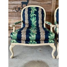 a blue and white chair with leopard print on the back, sitting in front of a wooden wall