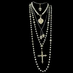 The Moonglow Sacred Heart Cross Rosary Necklace is designed as a true five decade rosary. It is 30" inches long and comes with a 4" complimentary enhancer that allows the necklace to be double. It features 9mm Silver Freshwater Pearls, mini Fleur de Lis and a reproduction French Sacred Heart Cross. The cross is two sided with the Sacred Heart on one side and a Lily at the center of the reverse. Length: 30" Gemstones: Silver Fresh Water Pearls Metal: Sterling Silver Clad Bronze Long Layered Pearl Necklace, Freshwater Pearls Jewelry, Silver Necklace Long, Spiritual Necklace With Miraculous Medal And Round Beads, White Spiritual Lariat Necklace, Spiritual White Lariat Necklace, White Spiritual Crucifix Necklace, White Crucifix Spiritual Necklace, White Miraculous Medal Spiritual Jewelry