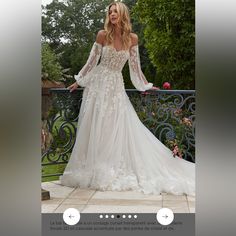 a woman in a wedding dress standing on a balcony with her arms out and looking off to the side