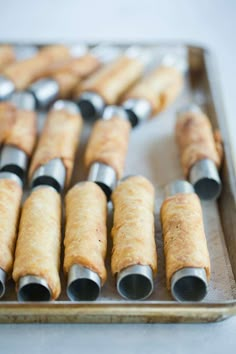 there are many different types of food in the trays on the table and one is made out of rolled up bread