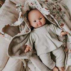 a baby doll laying on top of a blanket