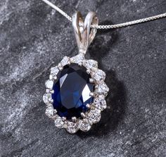 Diamond Pendant set with a Created Sapphire in a Diamond cut, flawless clarity & royal blue color, surrounded with small CZ Diamonds (8 Cts all).Solid 925 Sterling Silver ☞ made to last. Click here for ☞ Matching RingClick here for ☞ Matching Earrings Details:♥ Created Sapphire & CZ Diamonds in a flawless clarity♥ Sapphire: 14x10mm, 6 Ct, diamond cut♥ CZ Diamonds: 3mm each, 1.5 Ct combined, diamond cut♥ Dimensions: Pendant Height 30mm, Width 16mm♥ Free Complementary Chain♥ Solid 925 Sterling Sil Royal Blue Jewelry With Prong Setting For Formal Occasions, Sapphire Pendant With Diamond Accents, Sapphire Pendant Jewelry With Diamond Accents, Royal Blue Sapphire Jewelry With Prong Setting, Royal Blue Gemstone Fine Jewelry, Formal Royal Blue Sterling Silver Jewelry, Blue Diamond Oval Pendant Jewelry, Royal Blue Jewelry With Brilliant Cut As Gift, Elegant Sapphire Gemstones With Brilliant Cut