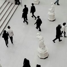 many people are walking around in the lobby area with stairs and steps leading up to them