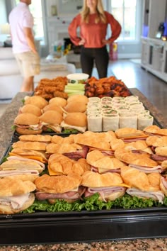 a table full of sandwiches and other food items