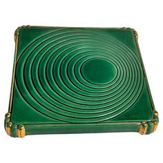 a green square shaped object with gold handles