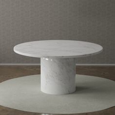 a white marble table sitting on top of a carpeted floor next to a wall