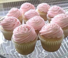 cupcakes with pink frosting sitting on a glass plate