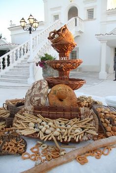 a table topped with bread and pretzels on top of a white table cloth