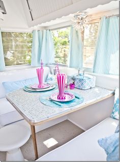 a table with plates and cups on it in front of a blue curtained window