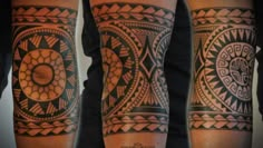 two men's legs with tattoos on them, one has an intricate design and the other has a geometric pattern