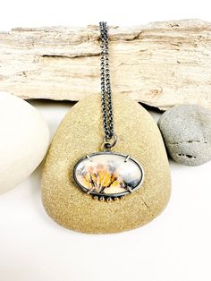 A beautiful dendritic agate doublet with a golden and orange tree like pattern is the focus of this pendant necklace. The pattern in the stone reminds me of a fall landscape. This one of a kind piece was handmade out of sterling silver, which has been given and oxidized patina to add contrast with the stones. Some of the high spots around the stones have been rubbed to remove some of the patina. At the top of the pendant is a a solid 18k gold ring and at the bottom are solid 18k gold ball detail Nature-inspired Necklace With Large Oval Pendant, Oval Cabochon Necklace With Nature-inspired Style, Nature-inspired Oval Agate Necklace, Oval Agate Necklace With Nature-inspired Style, Handmade Pendant Necklace, Fall Landscape, Orange Tree, Dendritic Agate, 18k Gold Ring