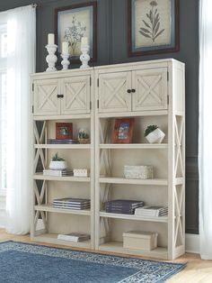 a white bookcase with drawers and pictures on the wall