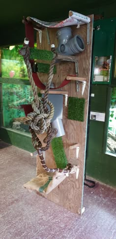 a wooden shelf with rope and plants on it