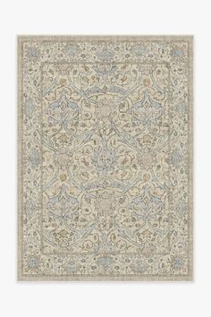 a beige rug with blue and green designs on the bottom, in an ornate pattern