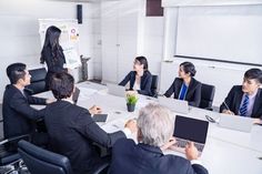 a group of people sitting around a conference table